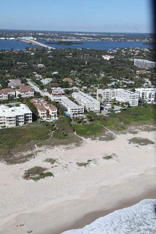 Beach up front with buildings and river in the background