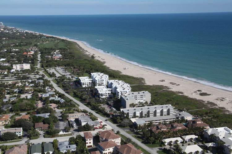 View of beach on the right side, hotel and other buildings on the left