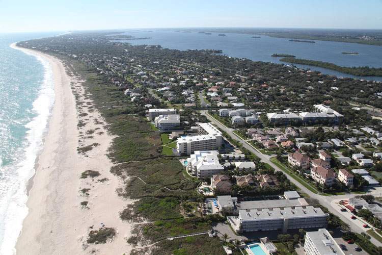 View of beach on the left and buildings and river on the right