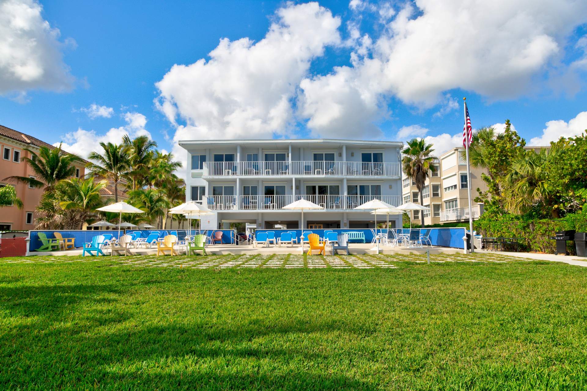 Back of the Prestige Hotel with lawn chairs and umbrellas