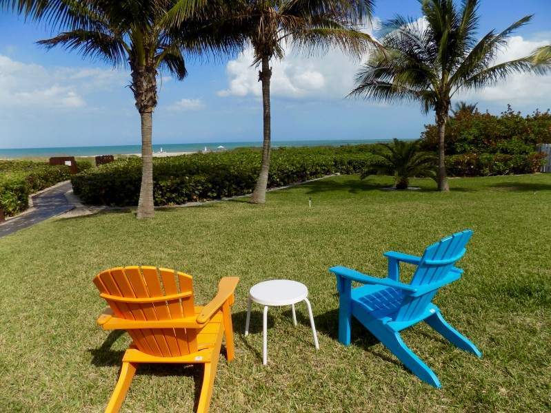 Orange and blue lawn chairs sitting out with the beach in the background